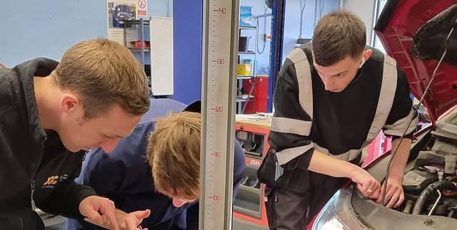 Students working on a vehicle in the motor vehicle workshop