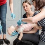 Students practicing Emergency Paediatric First Aid on a dummy of a child