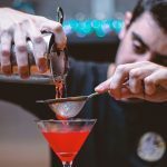 A bartender making a cocktail at a bar