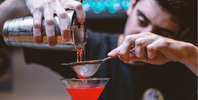 A bartender making a cocktail at a bar