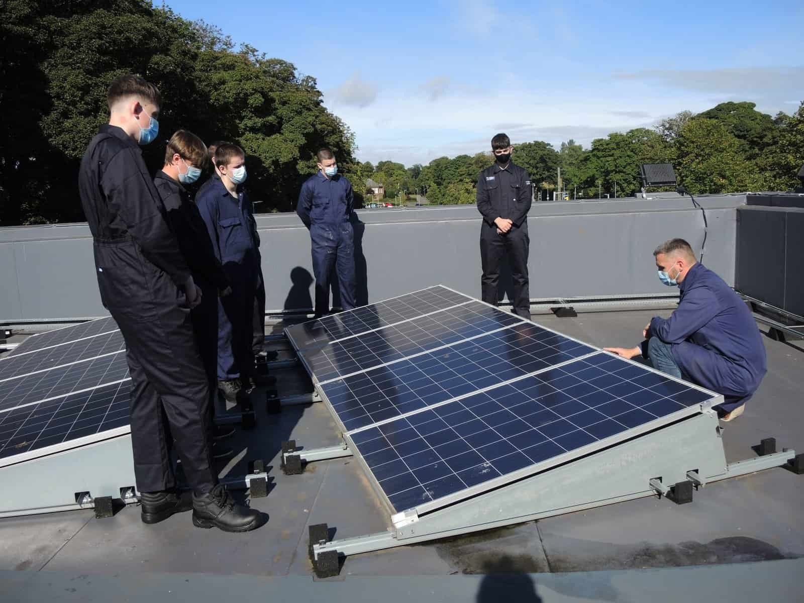 Green energy students around solar panels at Dumfries and Galloway College