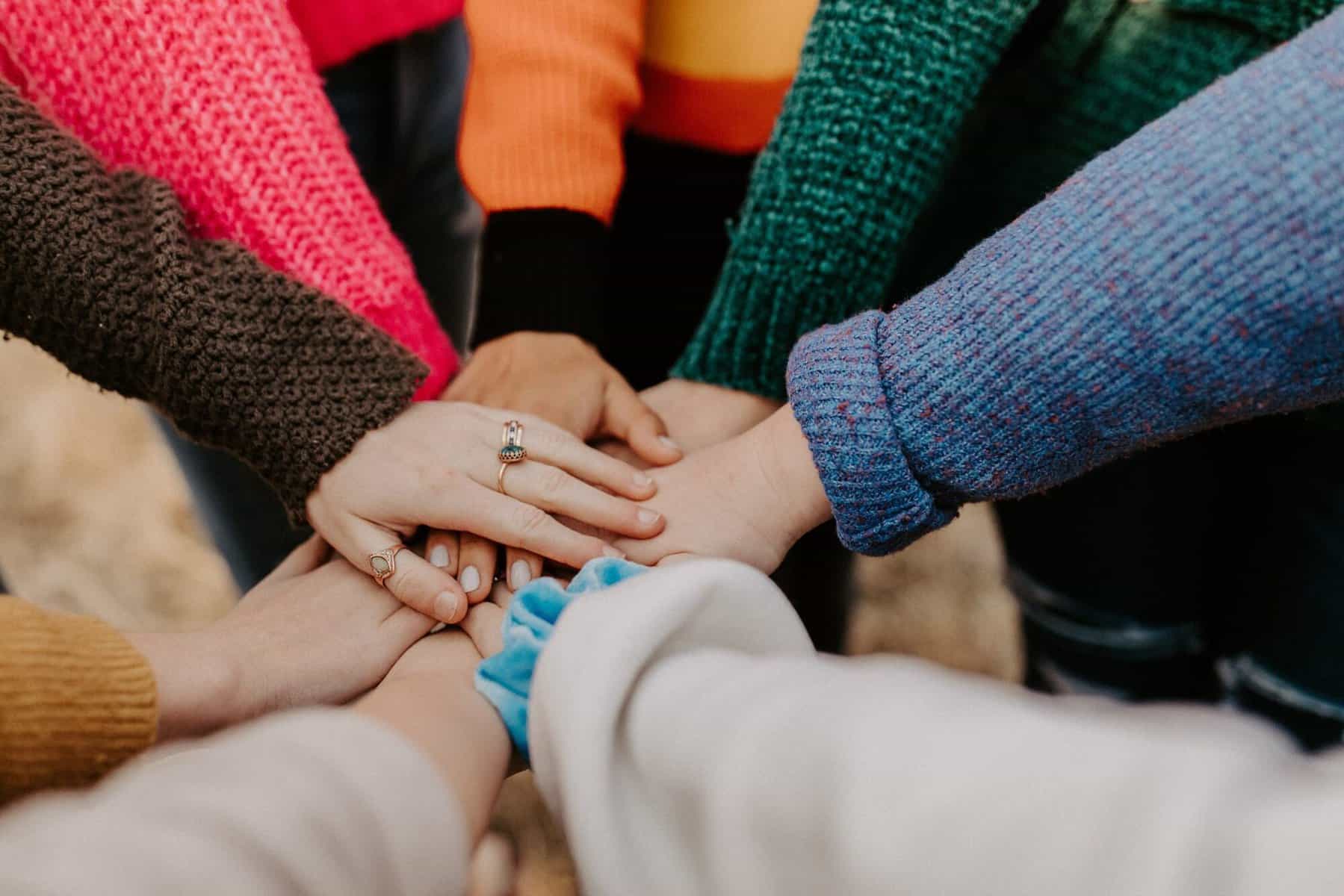 a group of people clasp hands.