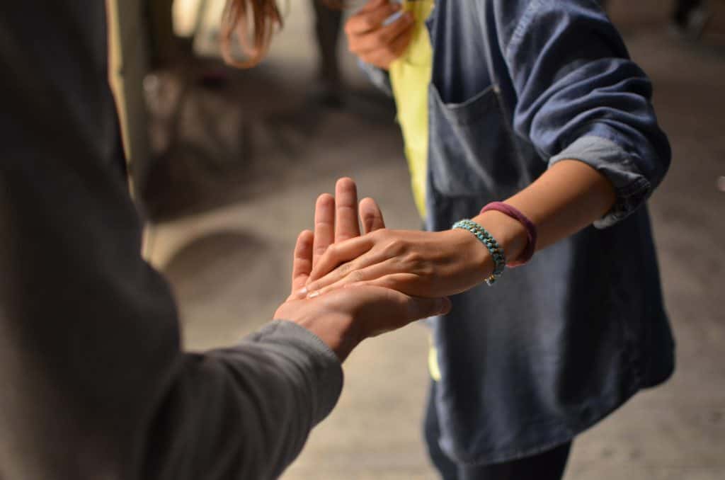 A pair of people clasp hands