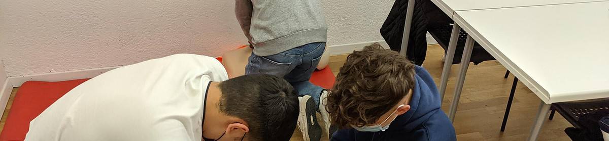 Students practicing CPR on a dummy in a classroom