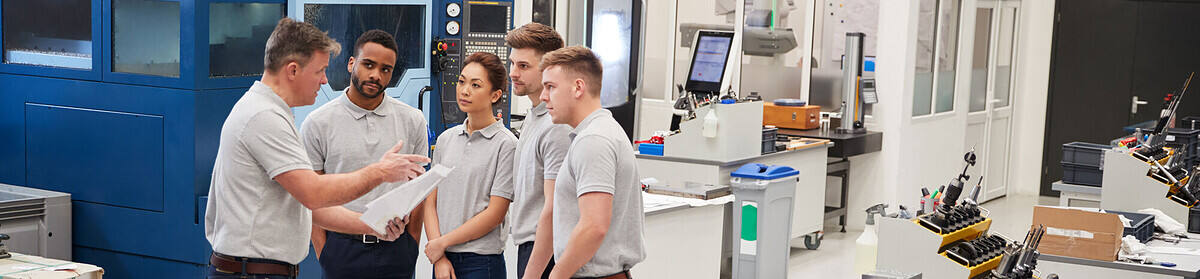 A group of apprentices receiving training in a work area.