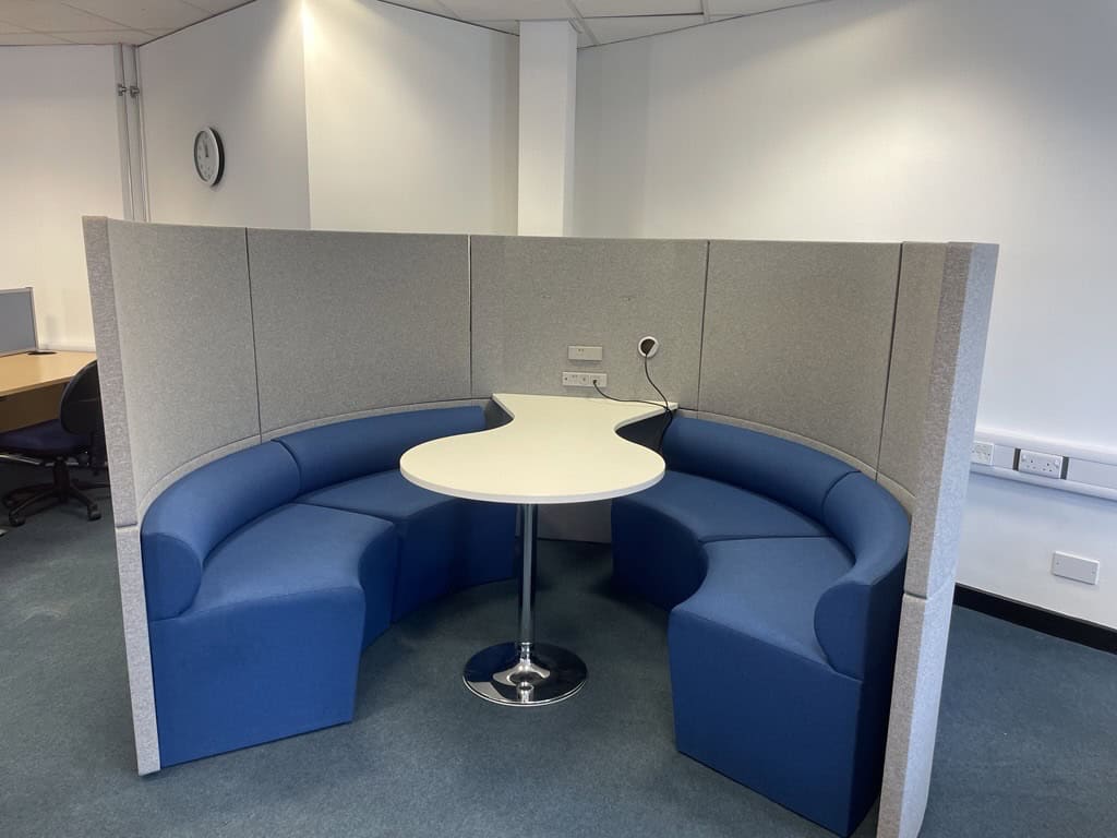 Circular blue seating with table in the middle.