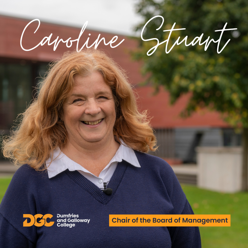 Smiling woman with red hair standing in front of a college building. 